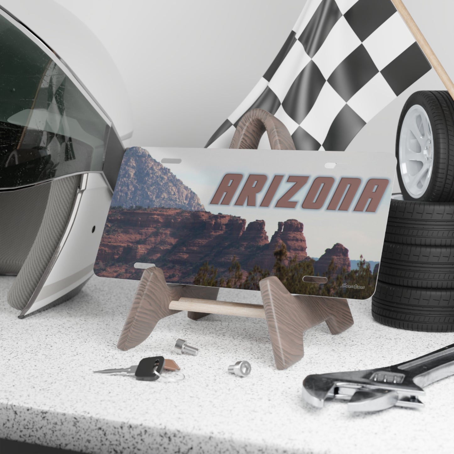 Arizona vanity plate displayed on a stand with a racing helmet and tools in the background