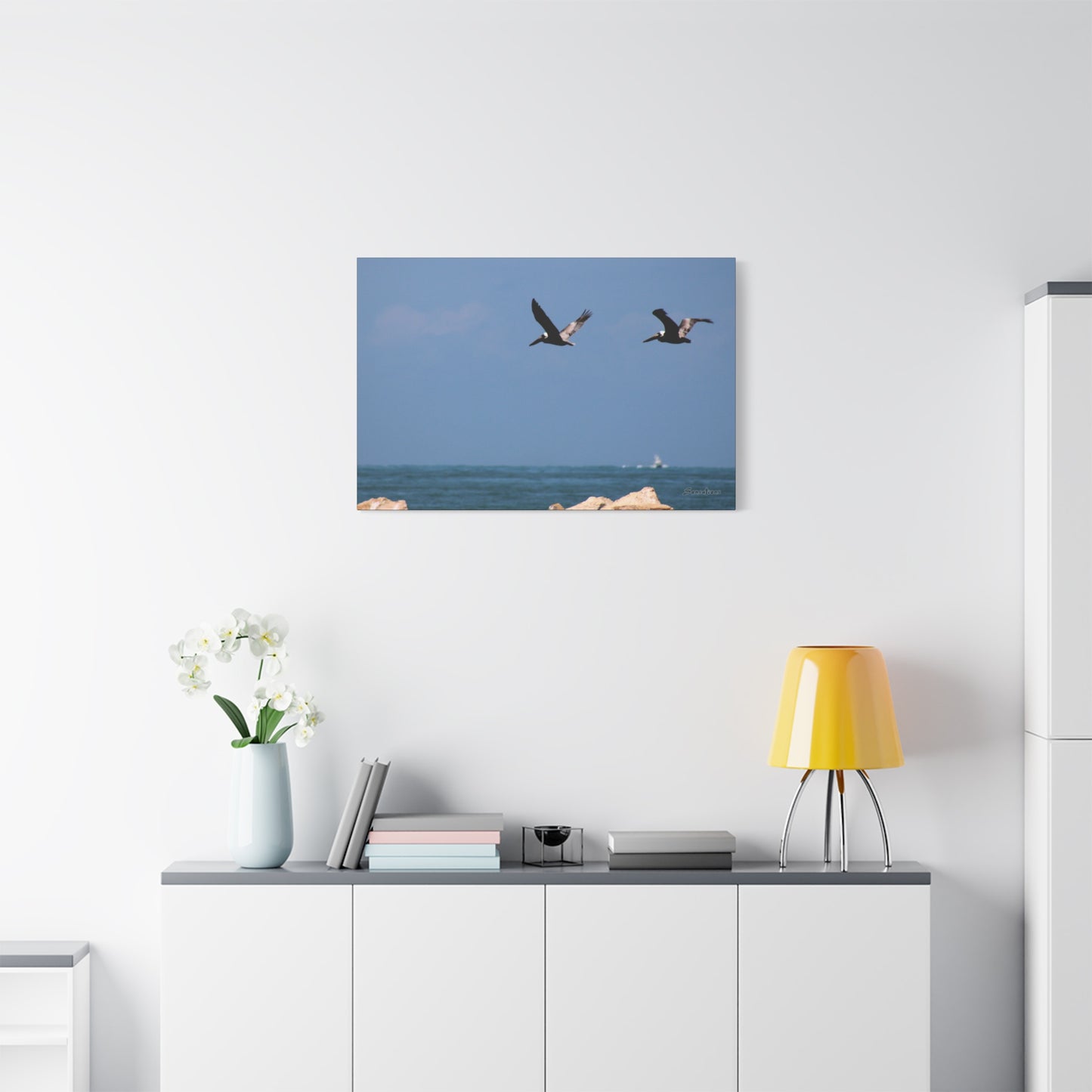 Coastal bird wall art featuring two birds flying over the ocean in a serene living room setting