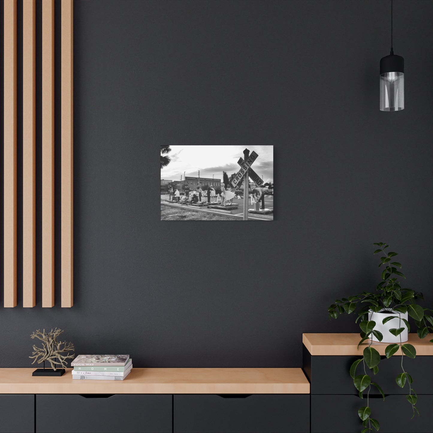 Marilyn Monroe canvas art displayed on a modern black wall with wooden accents and decorative plants