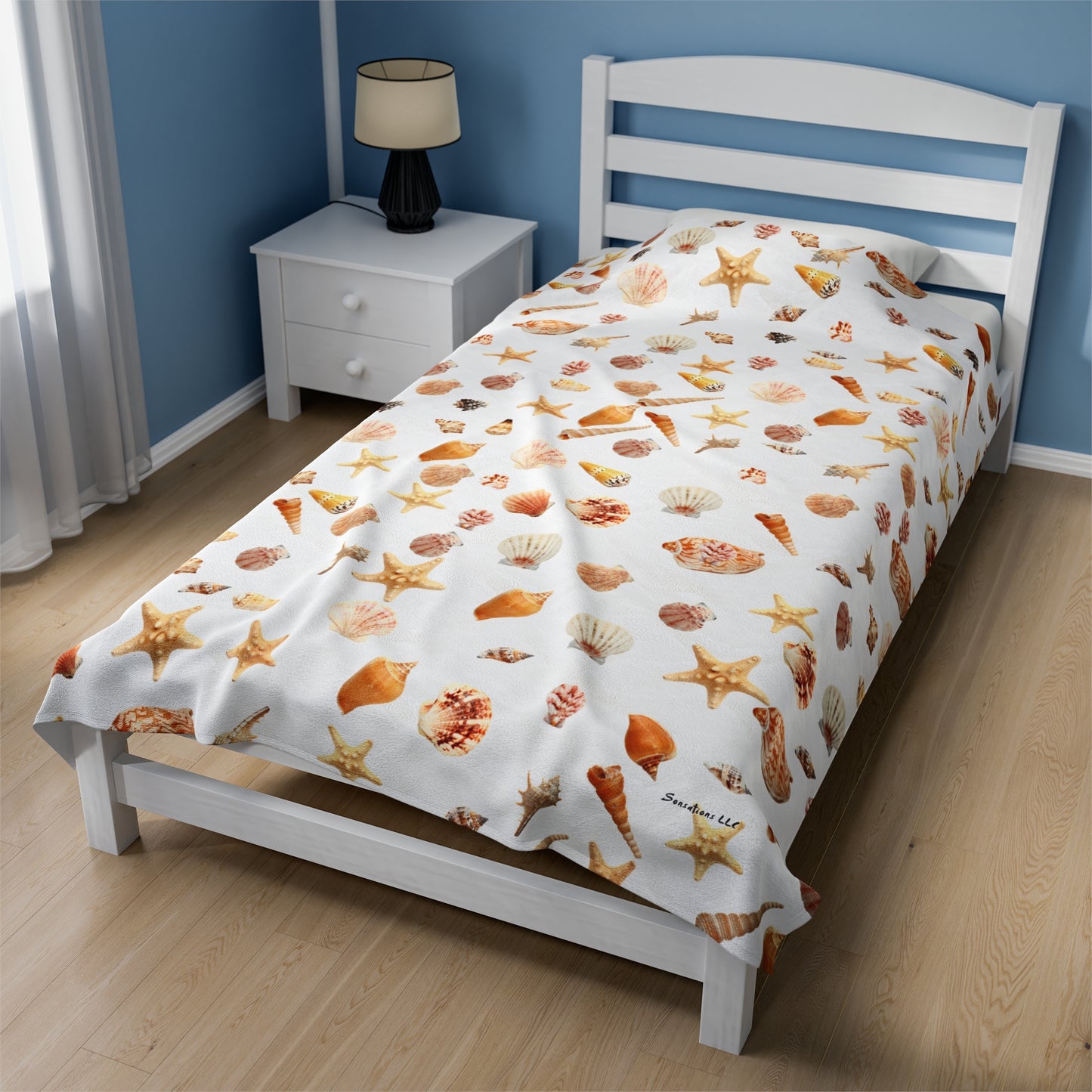 Sea shell velveteen blanket with colorful shell patterns on a bed in a cozy bedroom setting