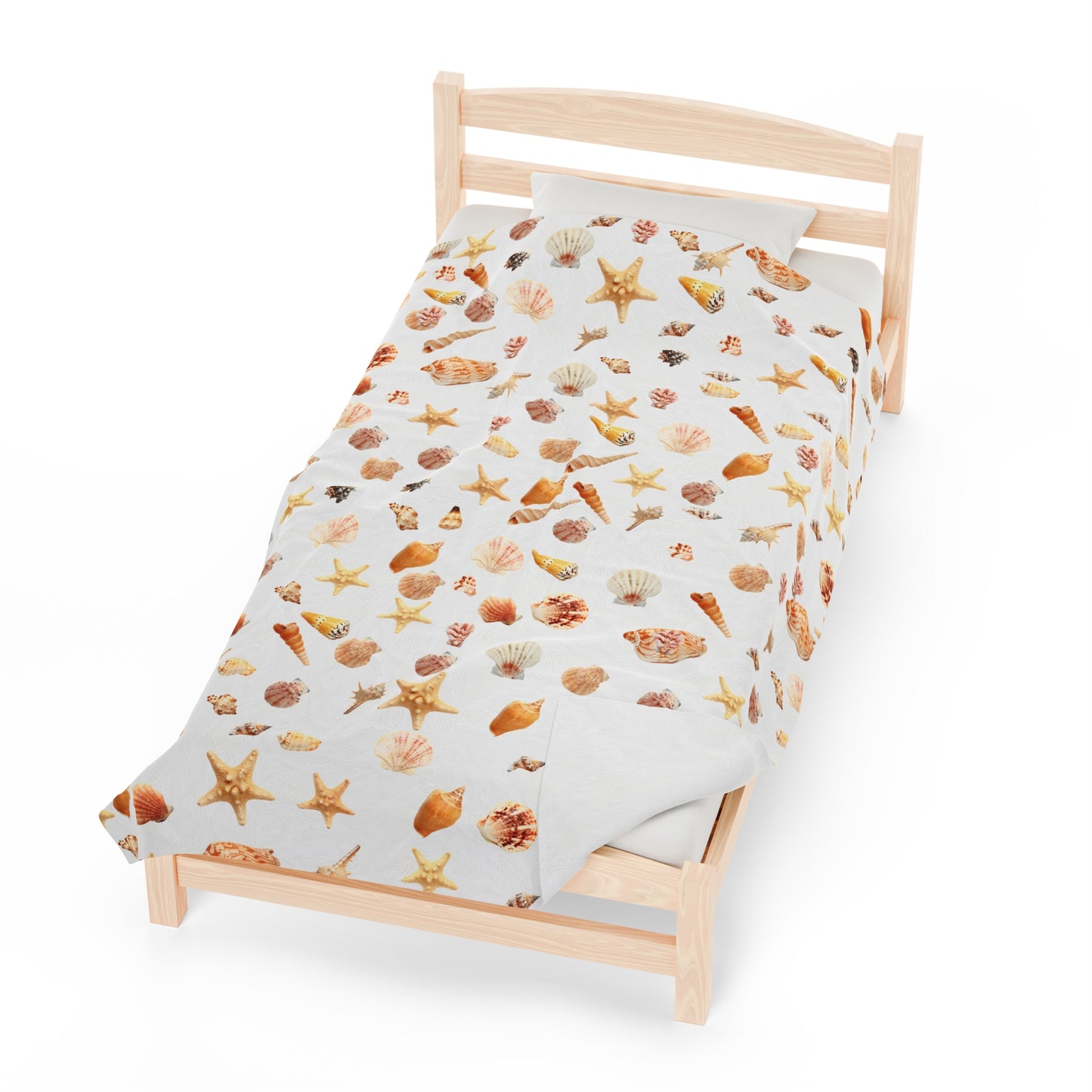 Sea shell velveteen blanket featuring an all over print of colorful seashells on a bed
