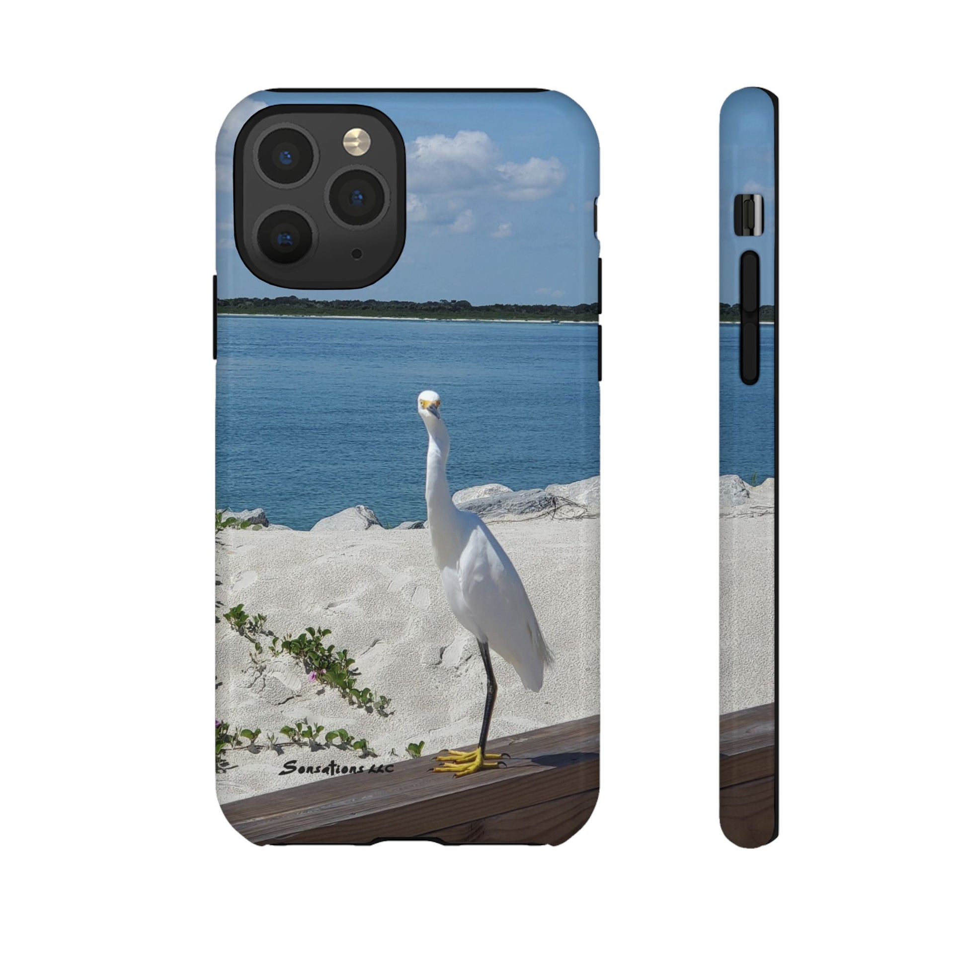 White bird phone case featuring a serene beach scene with a graceful bird by the water