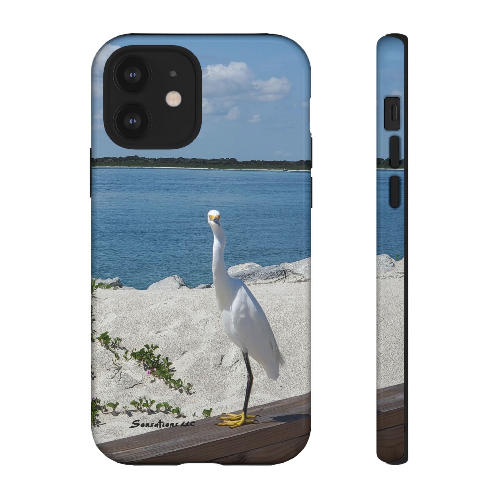 White bird phone case featuring a serene beach scene with a white heron standing near the water